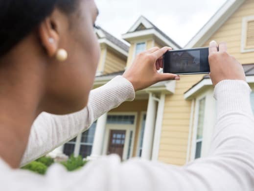 Woman Taking Picture of Home