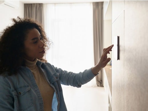 Woman Looking at Thermostat