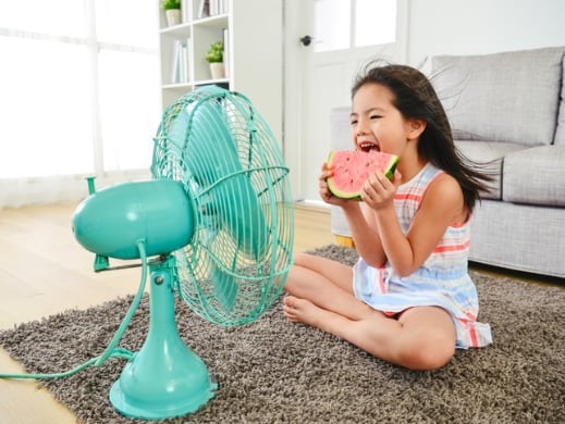 Girl eating watermelon and a fan