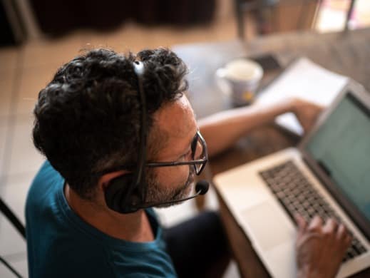 Man working at home with headset and coffee