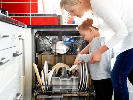Mother and son loading dishwasher