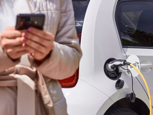 Woman Charging EV with Phone