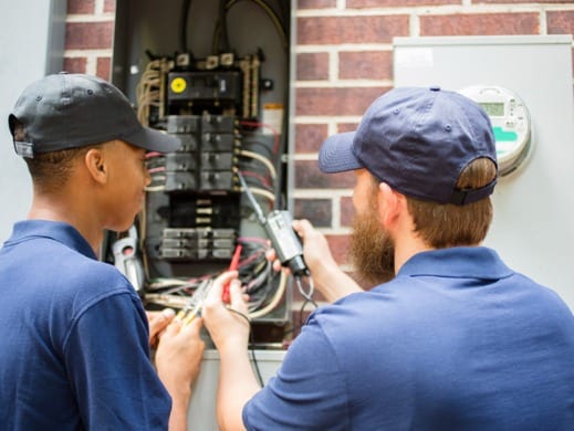 Electricians working on electrical panel