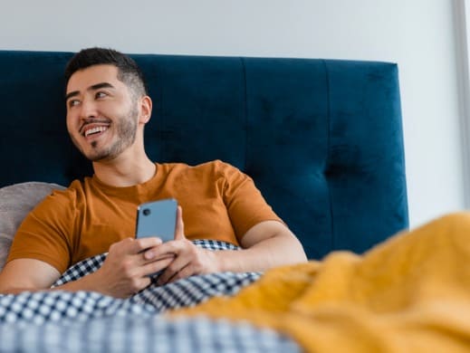 Man in bed with a phone