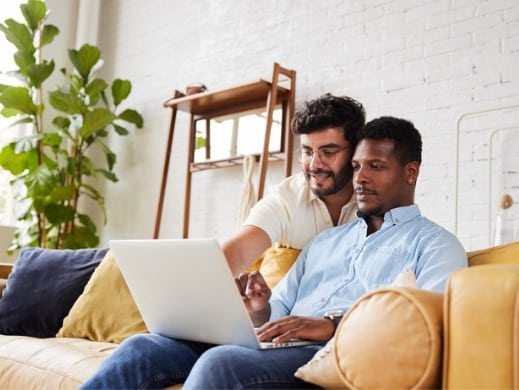 Men looking at laptop on couch