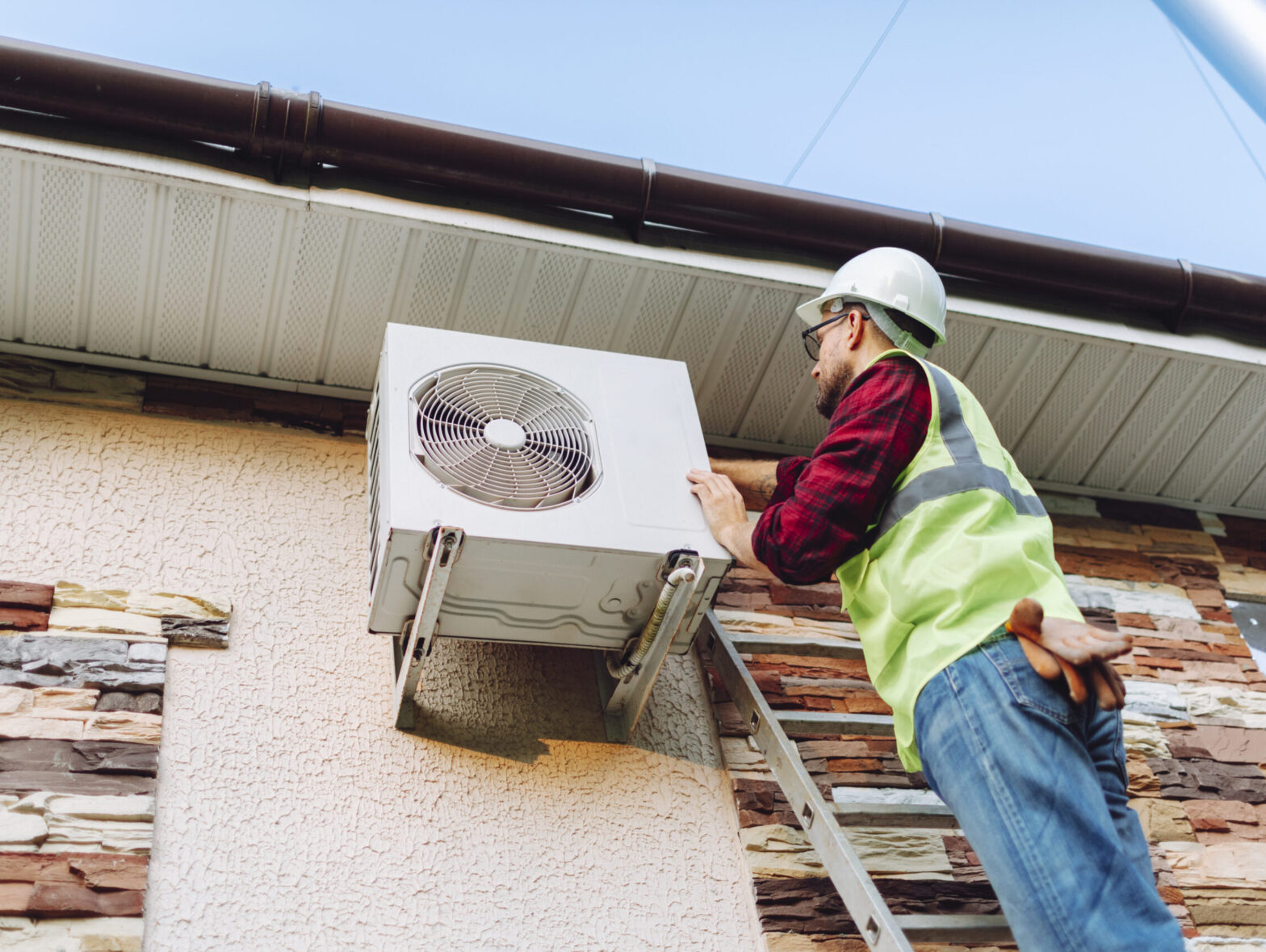 Technician in uniform repairing heat pump